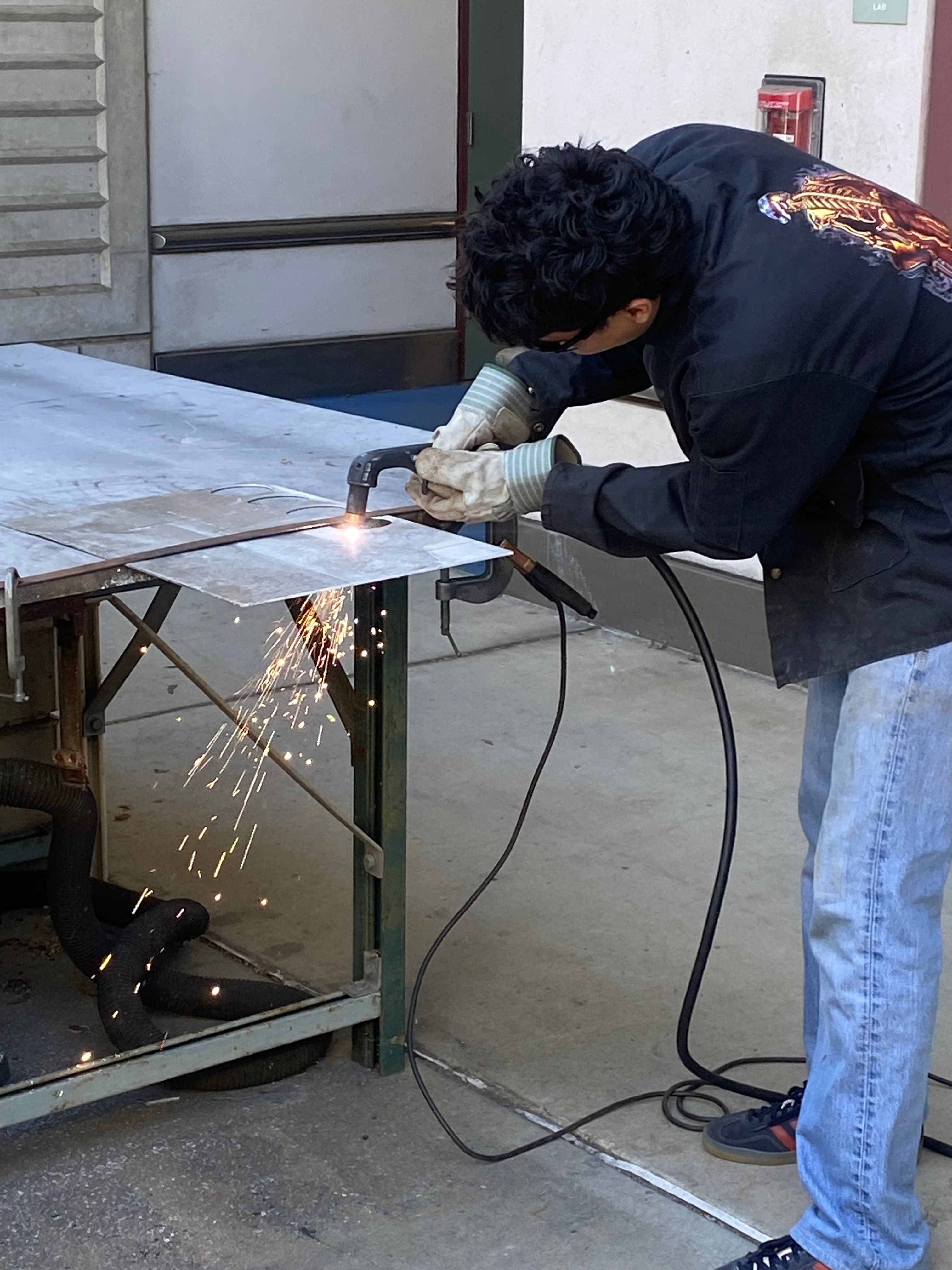 Marcus Greenan cutting sheet metal in the machine shop